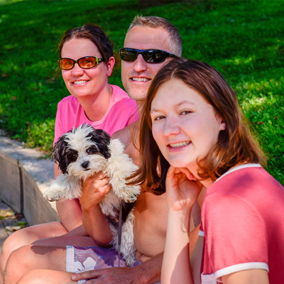 A smiling family and their pet dog